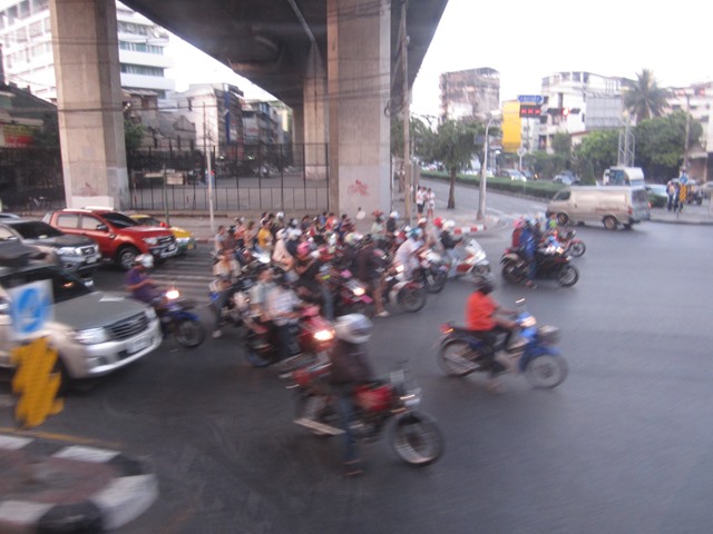 バイクが一斉に発信する夕暮れのタイの道路
