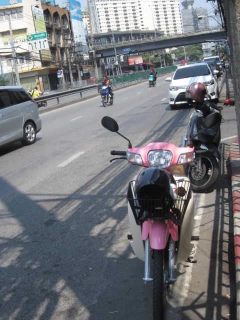 バンコクの道路に駐車するバイクや自動車