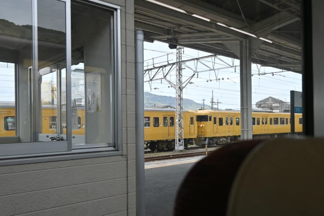 糸崎駅停車中の電車から留置線の黄色い電車を見る