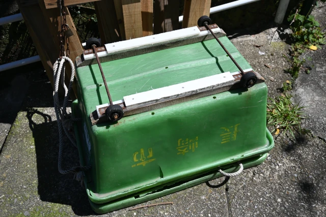 長崎の坂でゴミを運ぶ緑のソリ